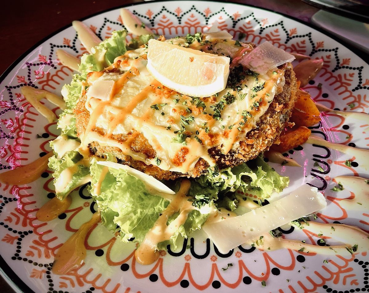 Breaded cutlet with melted cheese, shaved cheese and lettuce, by Chef Moreno Benigno