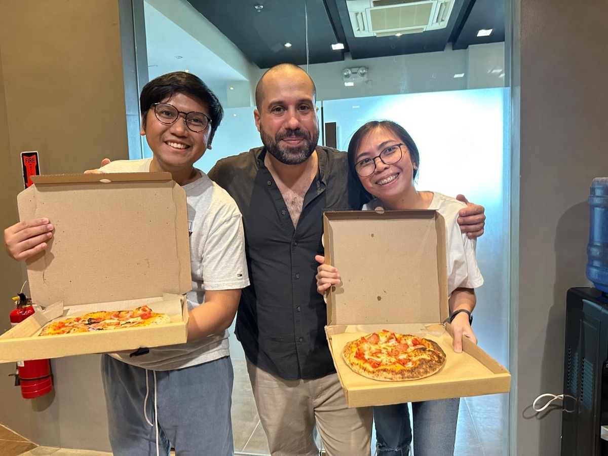 Chef Moreno Benigno with students and the pizzas they made at KESSLER'S Kitchen